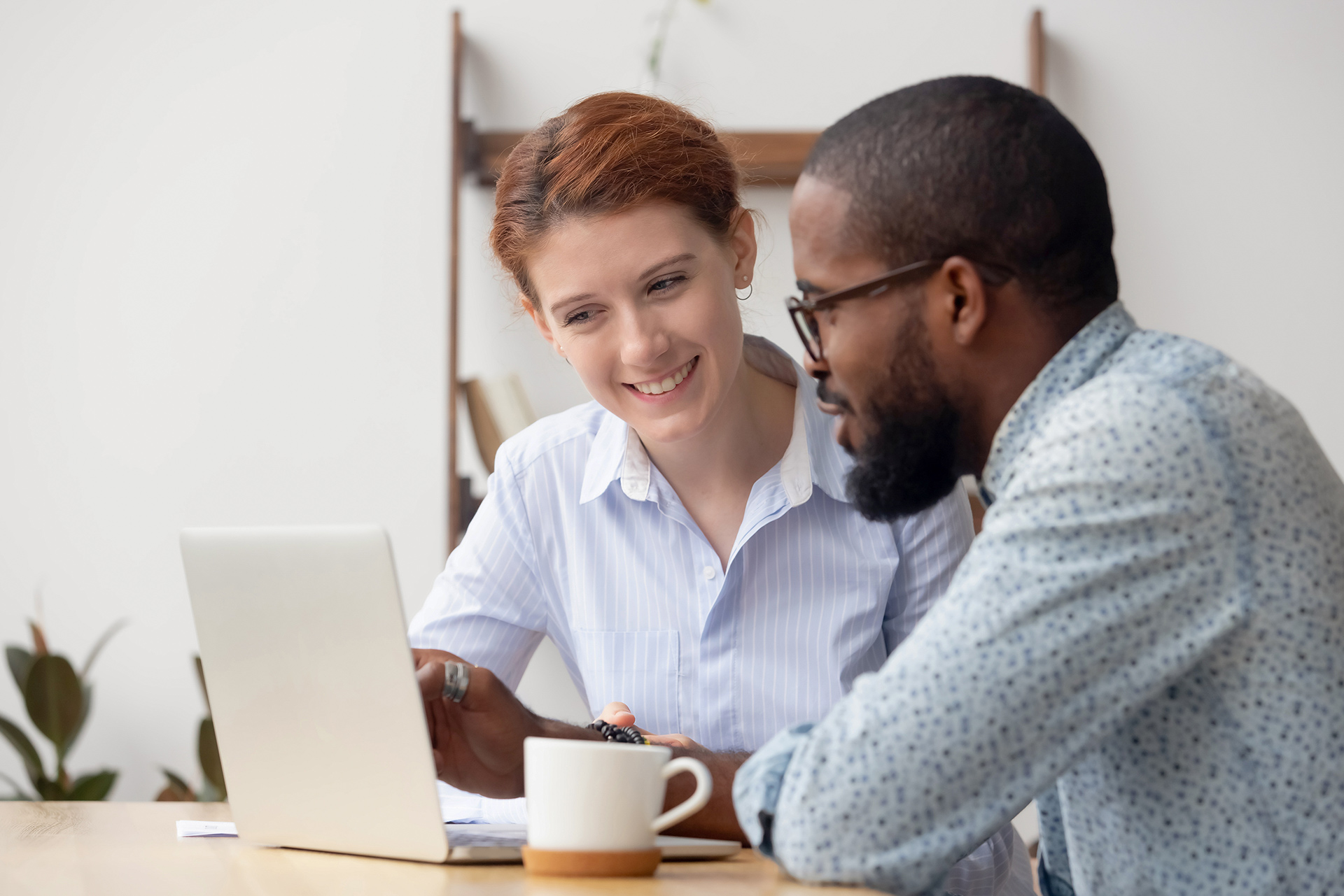 Two people chatting with coffee and laptop
