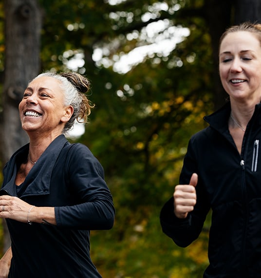 Two women smiling while running