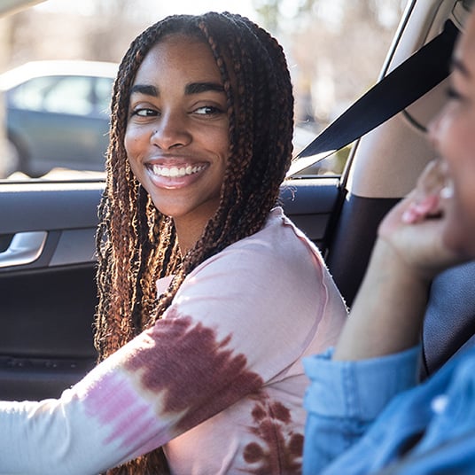 Smiling young girl driving a car